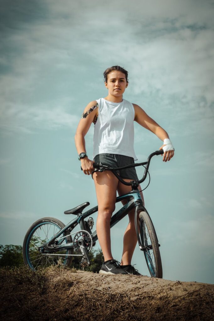woman in white tank top riding on black bicycle
